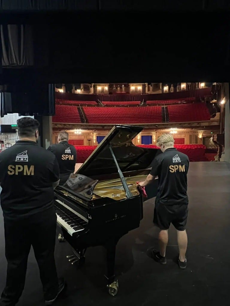 Specialist Piano Movers team with a Steinway grand on a theatre stage