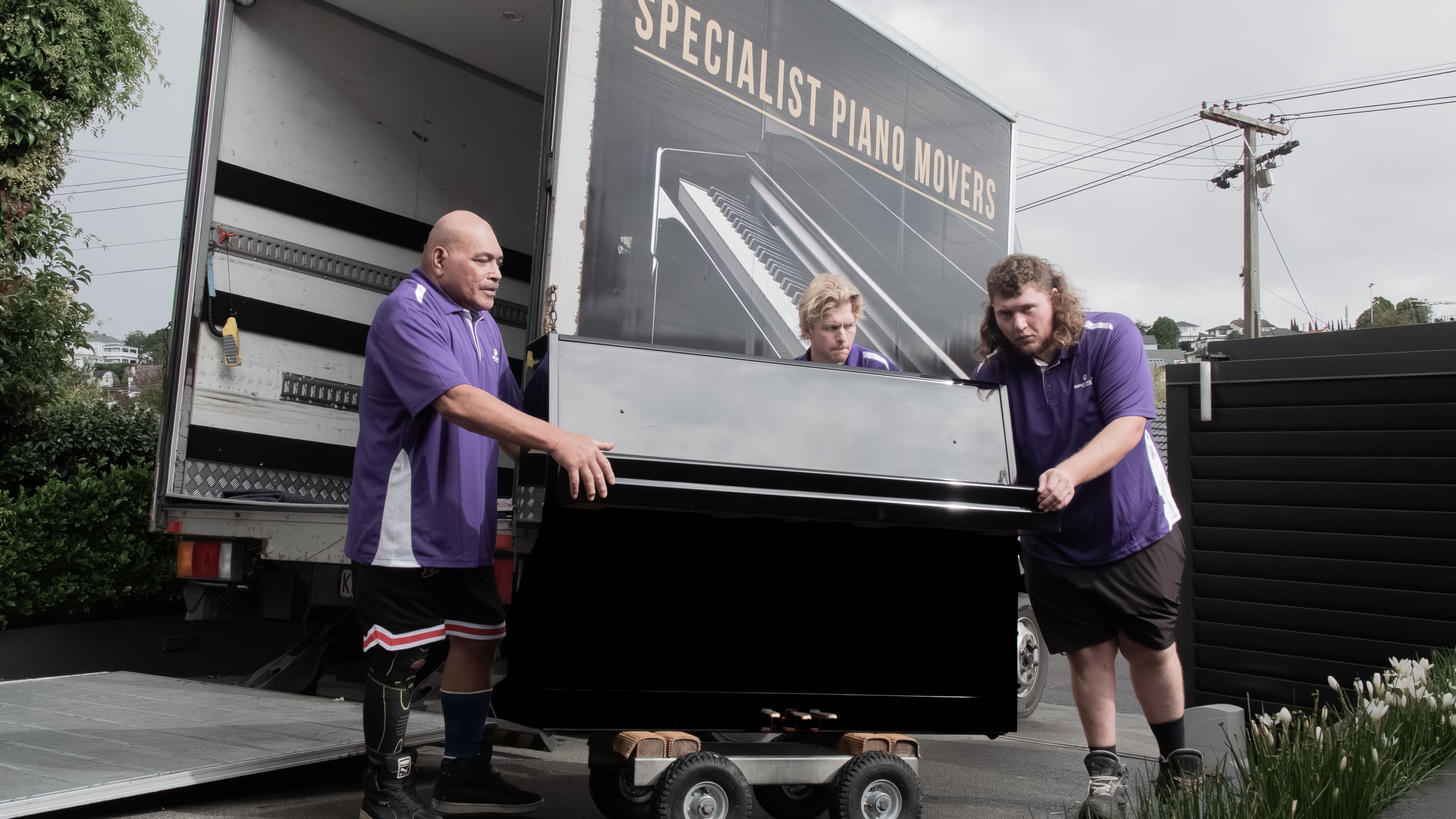 Specialist Movers crew carrying office boxes through glass doors