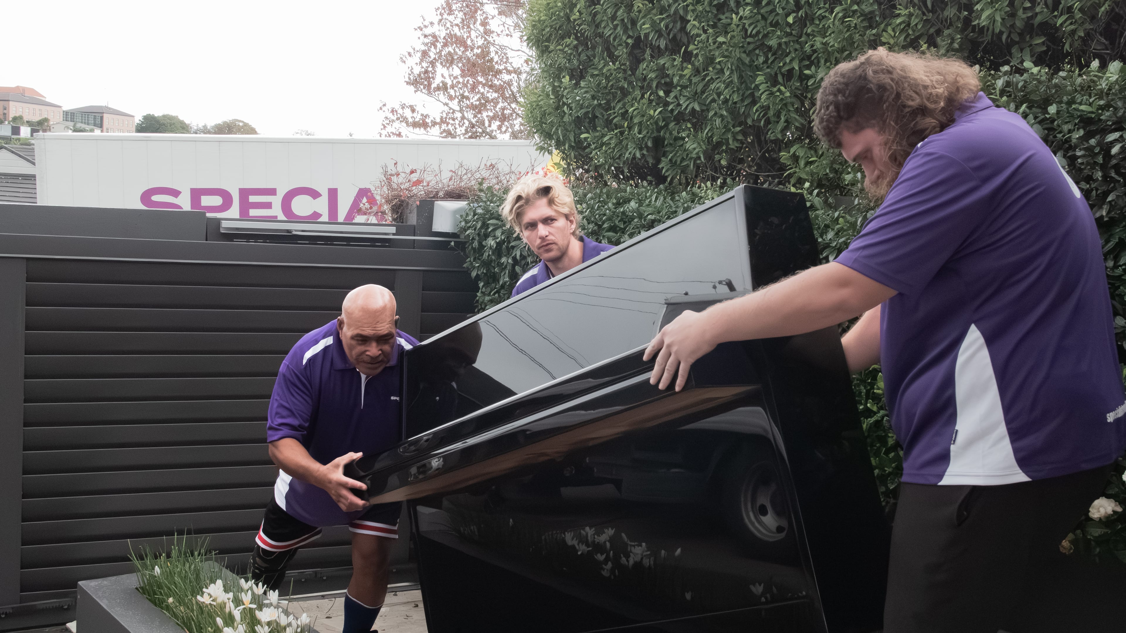 Specialist Movers crew moving a piano carefully
